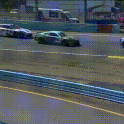 A Blue And White Race Car Is Driving Down A Track . GIF