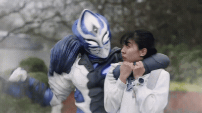 A Blue And White Superhero Is Holding A Woman In His Arms GIF