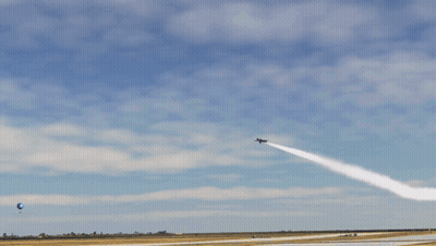 A Blue And Yellow Jet Is Flying Through A Blue Sky GIF