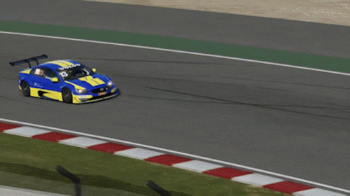 A Blue And Yellow Race Car Is Driving Down A Road GIF