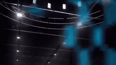 A Blue Bird Is Flying In The Air In Front Of A Blue Hexagon Wall . GIF