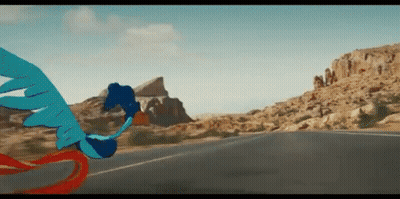 A Blue Bird Is Flying Over A Road In The Desert . GIF