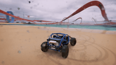 A Blue Buggy Is Driving Down A Sandy Beach GIF
