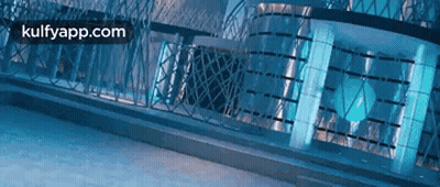 A Blue Building With A Fence In Front Of It And The Words Kulfyapp.com On The Bottom . GIF