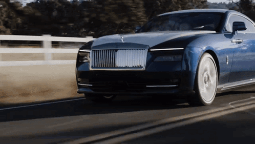 A Blue Car Is Driving Down A Road With A Fence In The Background GIF