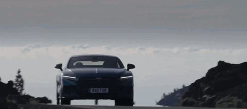 A Blue Car Is Driving Down A Road With A License Plate That Says ' Aao 108 ' On It GIF