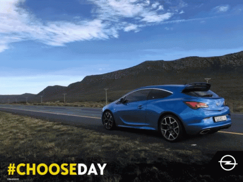 A Blue Car Is Driving Down A Road With Mountains In The Background And The Hashtag #Chooseday GIF