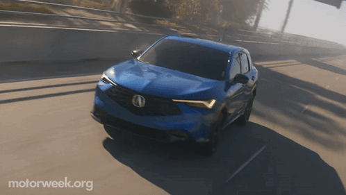 A Blue Car Is Driving On A Highway With Motorweek.org Written On The Bottom GIF