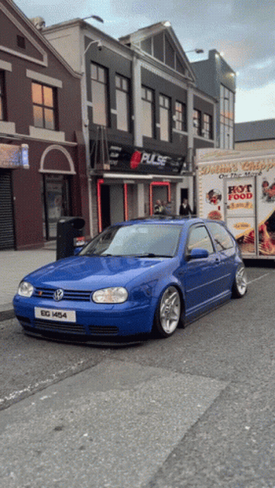 A Blue Car Is Parked In Front Of A Building That Says Pulse On It GIF