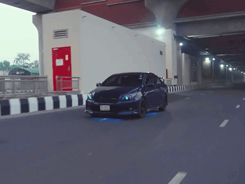 A Blue Car With A License Plate That Says ' A ' On It Is Driving Down A Road GIF