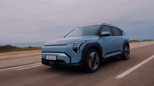 A Blue Car With A License Plate That Says Ehz-414E Is Driving Down A Road GIF