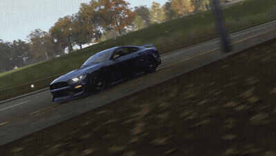 A Blue Car With A Red Stripe On The Front Is Driving Down A Road GIF