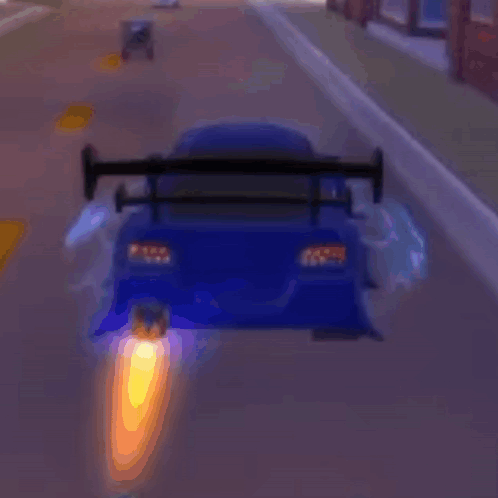 A Blue Car With A Wing Is Driving Down A Street . GIF