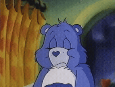 A Blue Care Bear With A Heart On Its Chest Looks Sad GIF