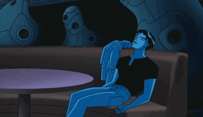 A Blue Cartoon Character Is Sitting On A Couch With A Table In The Background GIF
