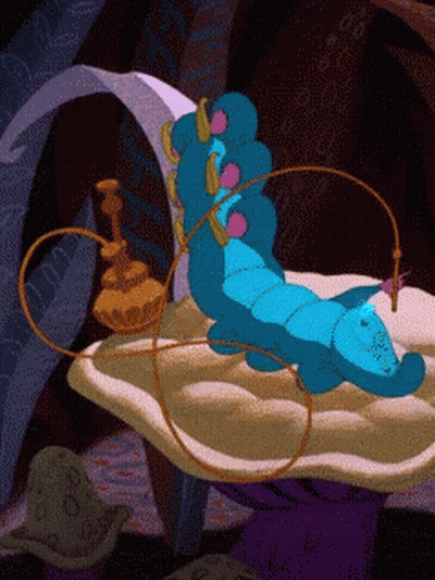 A Blue Caterpillar From Alice In Wonderland Is Laying On A Cushion GIF
