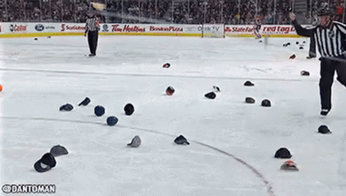 A Blue Hat Is Laying On The Ice Next To A Yellow Line . GIF