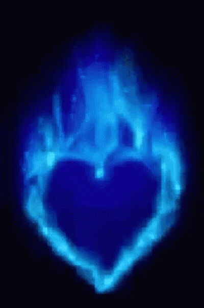 A Blue Heart Shaped Object Is Glowing In The Dark GIF