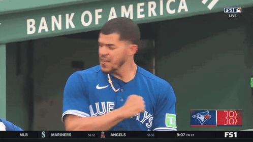 A Blue Jays Player Stands In Front Of A Bank Of America Banner GIF