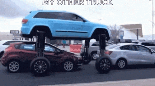 A Blue Jeep Is Sitting On Top Of A Red Car . GIF