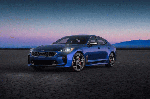 A Blue Kia Car Is Parked On A Dirt Road At Night GIF