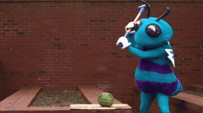 A Blue Mascot Is Cutting A Watermelon With A Hammer GIF