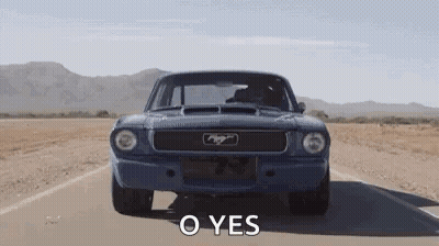 A Blue Mustang Is Driving Down A Desert Road With The Words `` O Yes '' Written On It . GIF