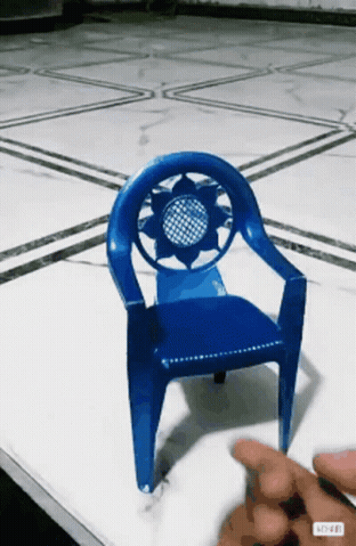 A Blue Plastic Chair With A Sunflower Design On The Back GIF