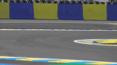 A Blue Race Car Is Going Around A Curve On A Race Track GIF