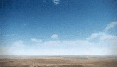 A Blue Sky With White Clouds Over A Desert Landscape GIF