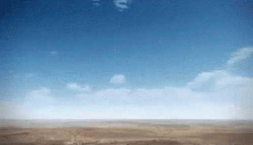A Blue Sky With White Clouds Over A Desert Landscape GIF