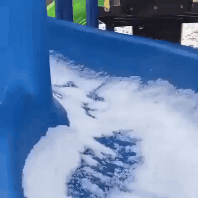 A Blue Slide With Foam Coming Out Of It Is Covered In Snow . GIF