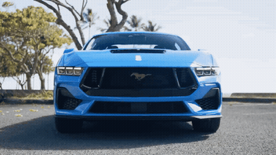 A Blue Sports Car With A Horse On The Front GIF