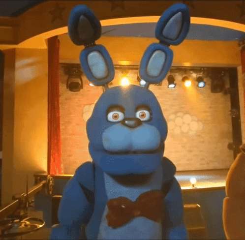 Blue Stuffed Animal With Bow Tie On Stage GIF