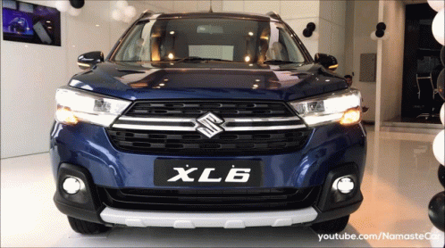A Blue Suzuki Xl6 Is On Display At A Dealership GIF