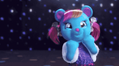 A Blue Teddy Bear With Pink Hair And A Purple Dress GIF
