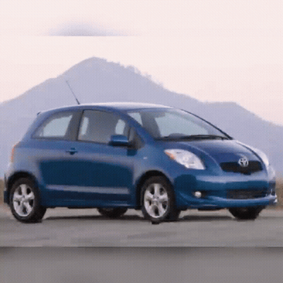 A Blue Toyota Car Is Parked On The Side Of A Road GIF
