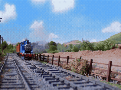 A Blue Train Is Going Down The Tracks In The Countryside GIF