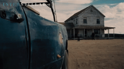 A Blue Truck Is Parked In Front Of A House With Interstellar Written On The Bottom GIF