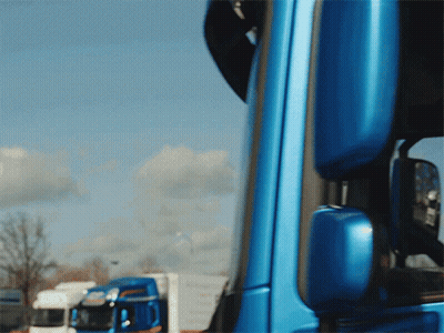 A Blue Truck Is Parked In Front Of A White Truck GIF