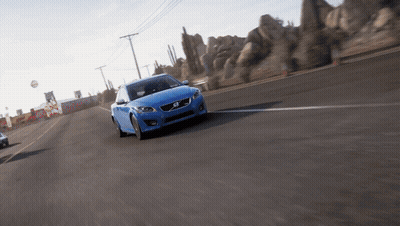 A Blue Volvo Is Driving On A Desert Road GIF