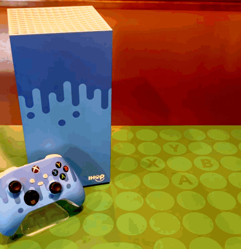 A Blue Xbox Controller Sits On A Table Next To A Box That Says Ihop GIF