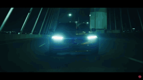 A Blurred Image Of A Car Driving Down A Road At Night GIF