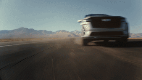 A Blurred Image Of A Car Driving Down A Road With Mountains In The Background GIF