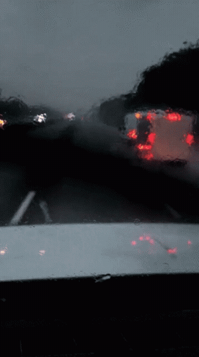 A Blurred Image Of A Car 'S Windshield With Red Lights Reflected In It GIF
