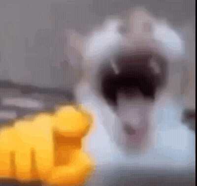 A Blurred Image Of A Cat With Its Mouth Open And A Yellow Finger Pointing At It . GIF