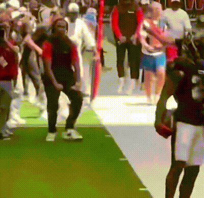 A Blurred Image Of A Crowd Of People Walking On A Green Carpet GIF