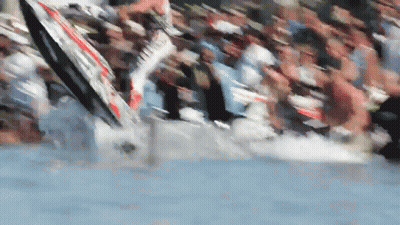 A Blurred Image Of A Crowd Of People Watching A Person On A Surfboard In The Water GIF