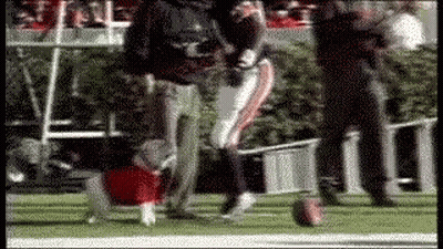 A Blurred Image Of A Football Player Kicking A Ball On The Field GIF