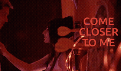 A Blurred Image Of A Man And Woman With The Words Come Closer To Me In Red GIF